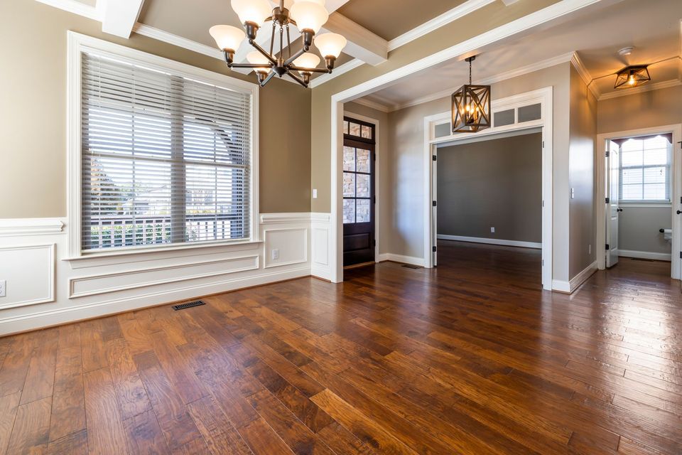 A cleared room with a bare wood floor, emptied and swept ready to hand back