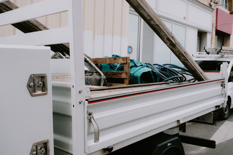 An open truck bed loaded with unwanted furniture and household material hauled away from a property